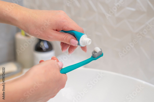 Woman holding toothbrush and toothpaste getting ready for morning routine photo