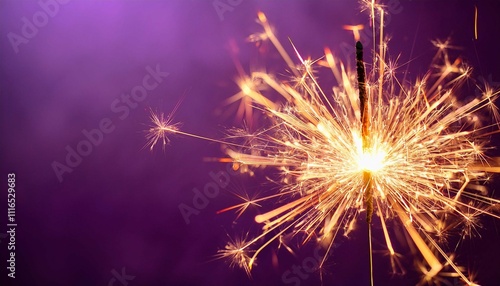 glittering burning sparkler on purple background