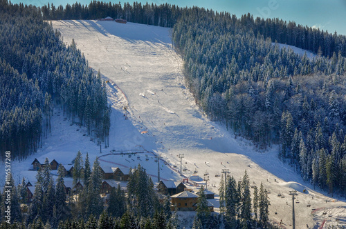 mountain winter landscape with snow-covered fir trees , ski track