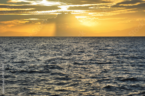 sunset seascape, sun rays through the clouds