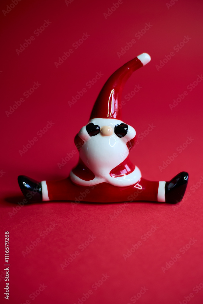 This charming and festive Santa figurine is designed in a playful pose that radiates holiday cheer