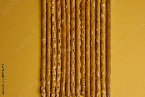 Obraz na płótnie Artfully arranged pretzel sticks are presented beautifully against a vibrant yellow background w salonie