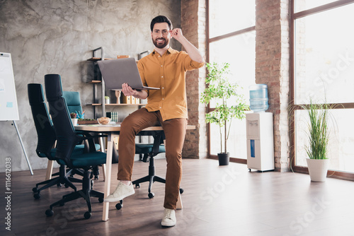 Full size photo of nice young male hold netbook wear yellow shirt formalwear coworking successful businessman nice light office photo