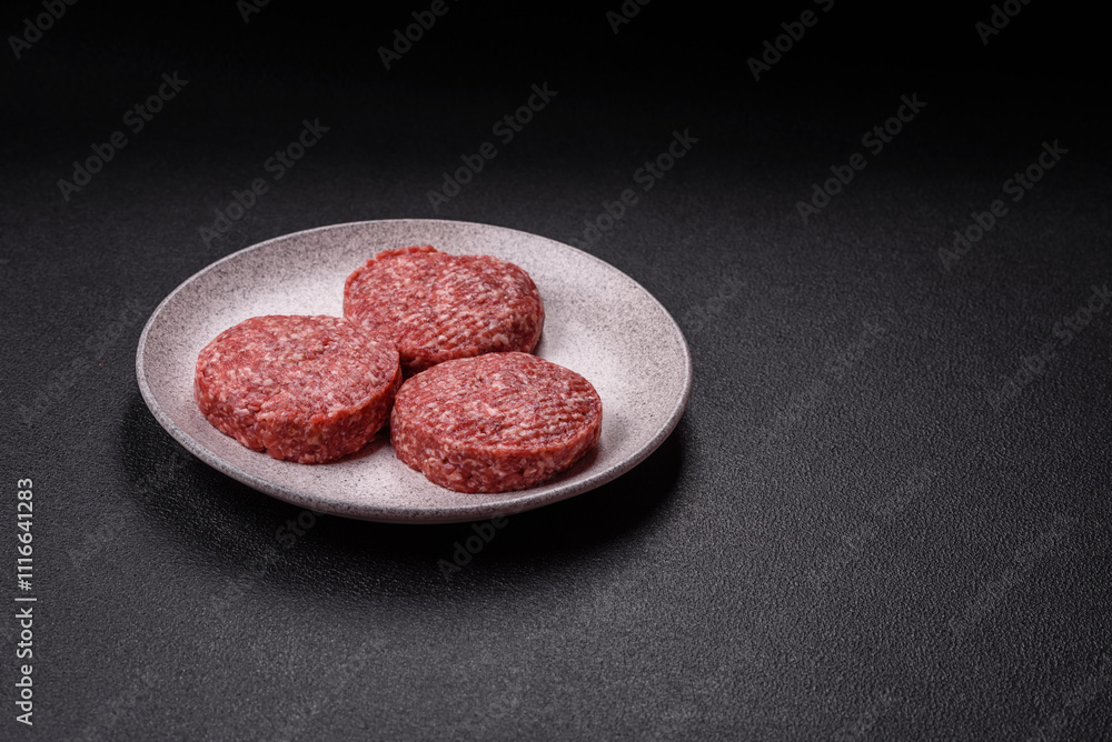 Fresh raw ground beef burger patty with salt and spices Fresh raw ground beef burger patty with salt and spices