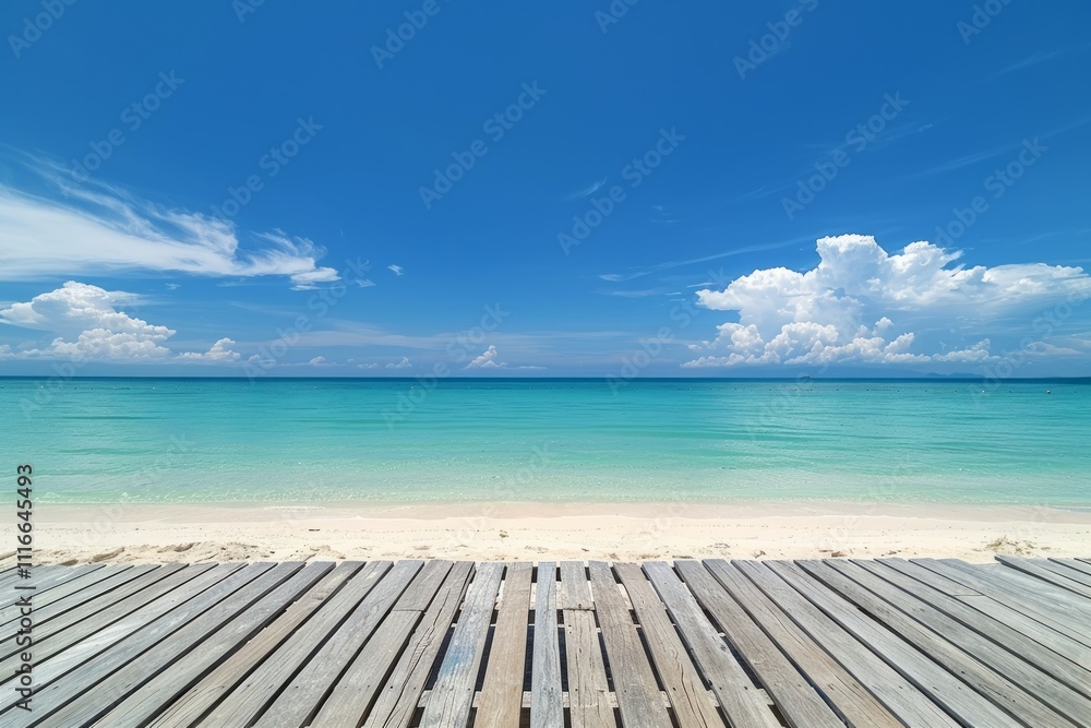Fototapeta premium A beautiful beach scene with a wooden deck, clear turquoise waters, and a bright blue sky with soft clouds