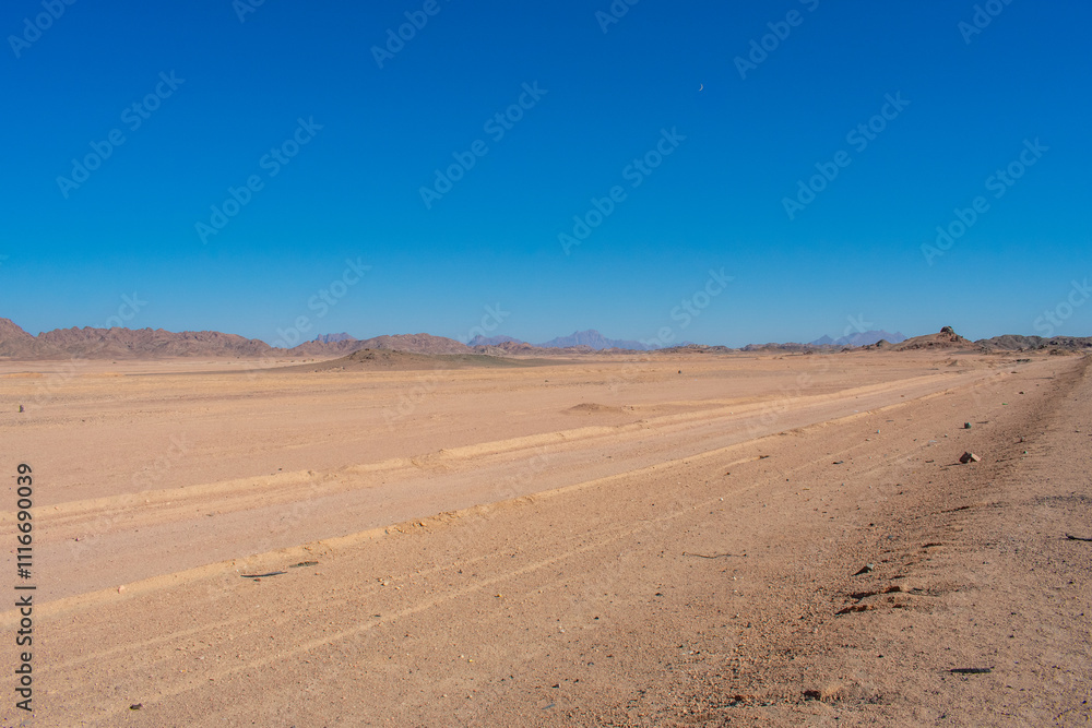 Road in middle of desert near Hurghada Egypt. Empty Asphalt road against blue sky Road in middle of desert near Hurghada Egypt. Empty Asphalt road against blue sky