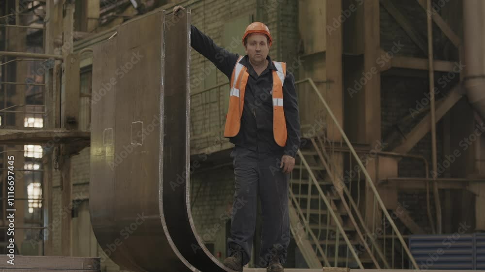 An industrial worker outfitted in full safety gear is actively engaged at a manufacturing facility. Stock Clip An industrial worker outfitted in full safety gear is actively engaged at a manufacturing facility. Stock Clip