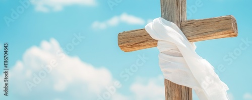 Wooden Cross Draped in White Cloth Against Blue Sky photo