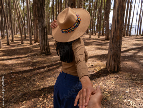 Latin tourist from behind holding hands with her partner in the Qenqo forest in Cusco photo