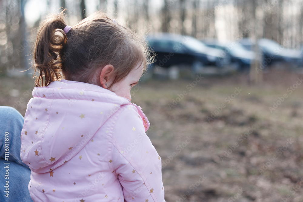 Sad little girl in pink jacket in winter park. Concept of sadness outdoors Sad little girl in pink jacket in winter park. Concept of sadness outdoors