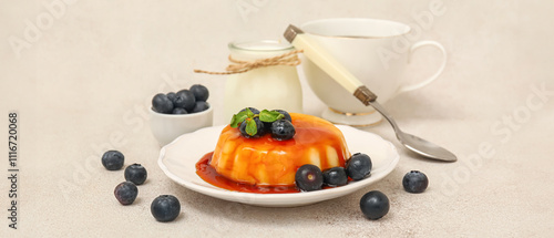 Plate with delicious pudding and blueberries covered by caramel syrup on white grunge background photo