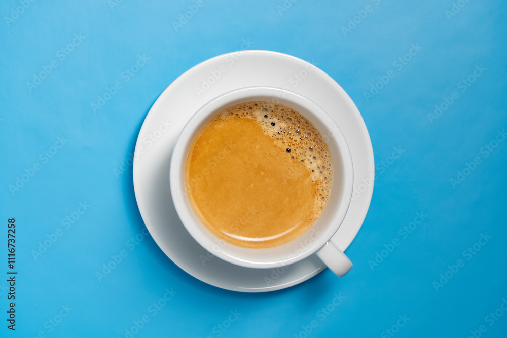 White cup with fresh black coffee on blue background, closeup, top view White cup with fresh black coffee on blue background, closeup, top view