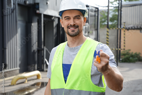 Male builder with earplugs ...