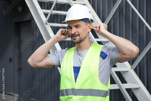 Male builder putting in ear...