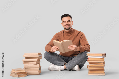 Handsome man reading book o...