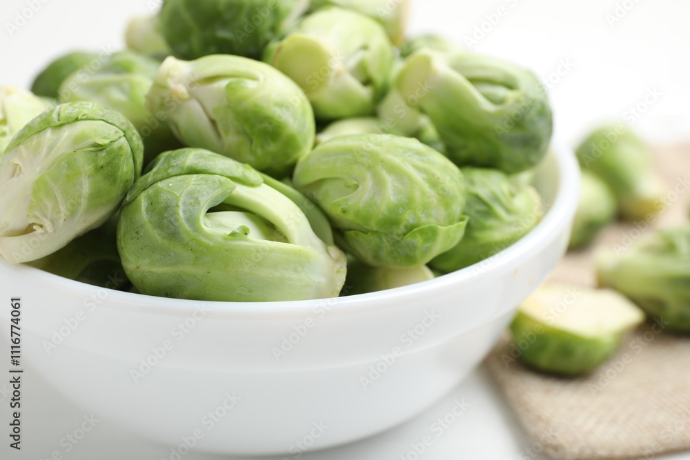 Fresh Brussels sprouts in bowl on white table, closeup Fresh Brussels sprouts in bowl on white table, closeup
