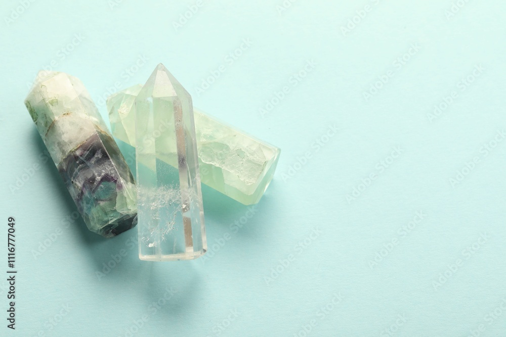 Beautiful natural gemstones on light blue background, top view. Space for text Beautiful natural gemstones on light blue background, top view. Space for text