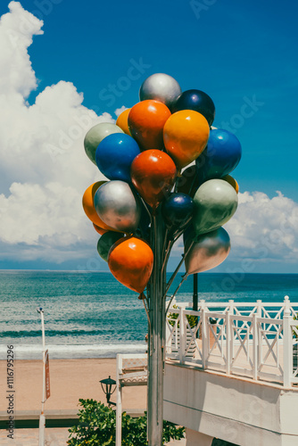 Landscape with a view of the beach and colorful balloons on the shore.