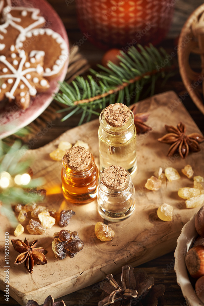 Three bottles of aromatherapy essential oils with frankincense resin, spruce tree and Christmas decoration Three bottles of aromatherapy essential oils with frankincense resin, spruce tree and Christmas decoration