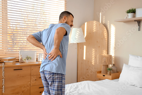 Young man in pajamas suffer...