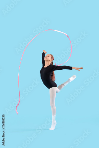 Teenage girl with ribbon doing gymnastics on blue background photo