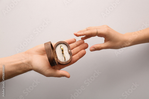 Couple holding wedding ring...