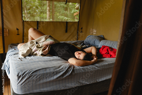 Woman resting on a bed in a tent photo