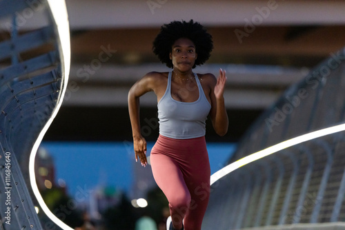 Female black athlete stride running urban bridge trail