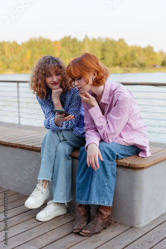 Two young women enjoying a sunny afternoon by the water photo