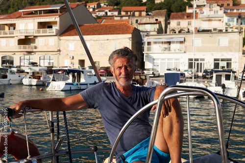 Portrait of a relaxed man sitting in the boat marina photo