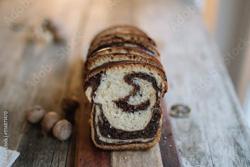 Sliced loaf of chocolate swirl bread on wooden board photo