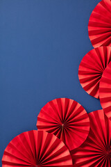 Chinese red paper fans on a blue background. Lunar New Year 2025 elements.