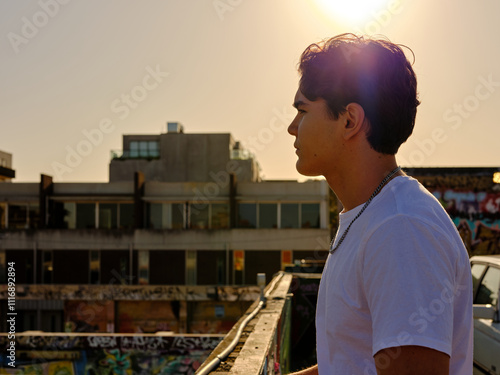 Portrait of young man on rooftop at sunset photo