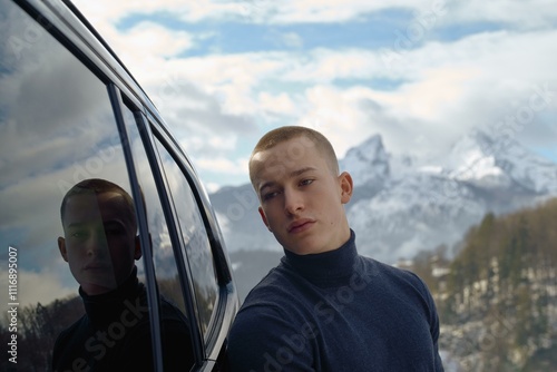 Contemplating mountains beside a sleek vehicle photo