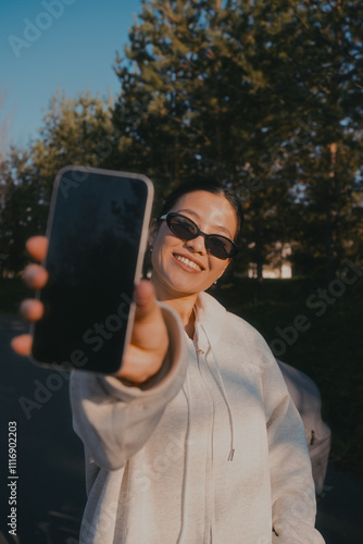 A woman points her phone screen at the camera photo