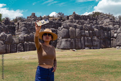 Latina tourist taking selfie at the Sacsayhuaman fortress in Cusco