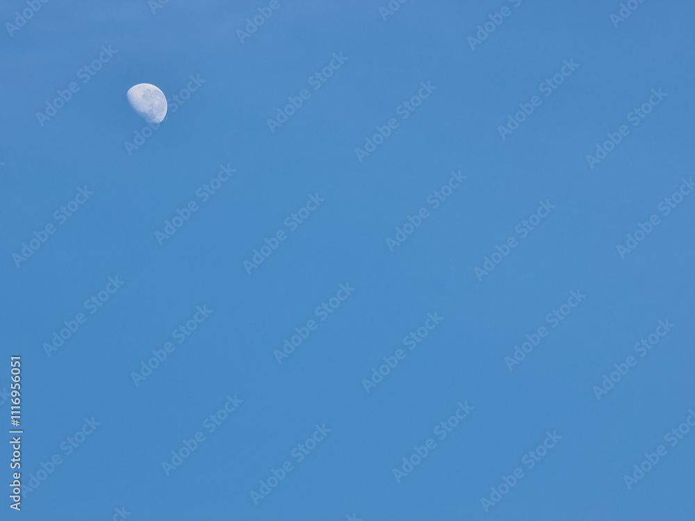 A crescent moon shines brightly in a clear blue sky A crescent moon shines brightly in a clear blue sky