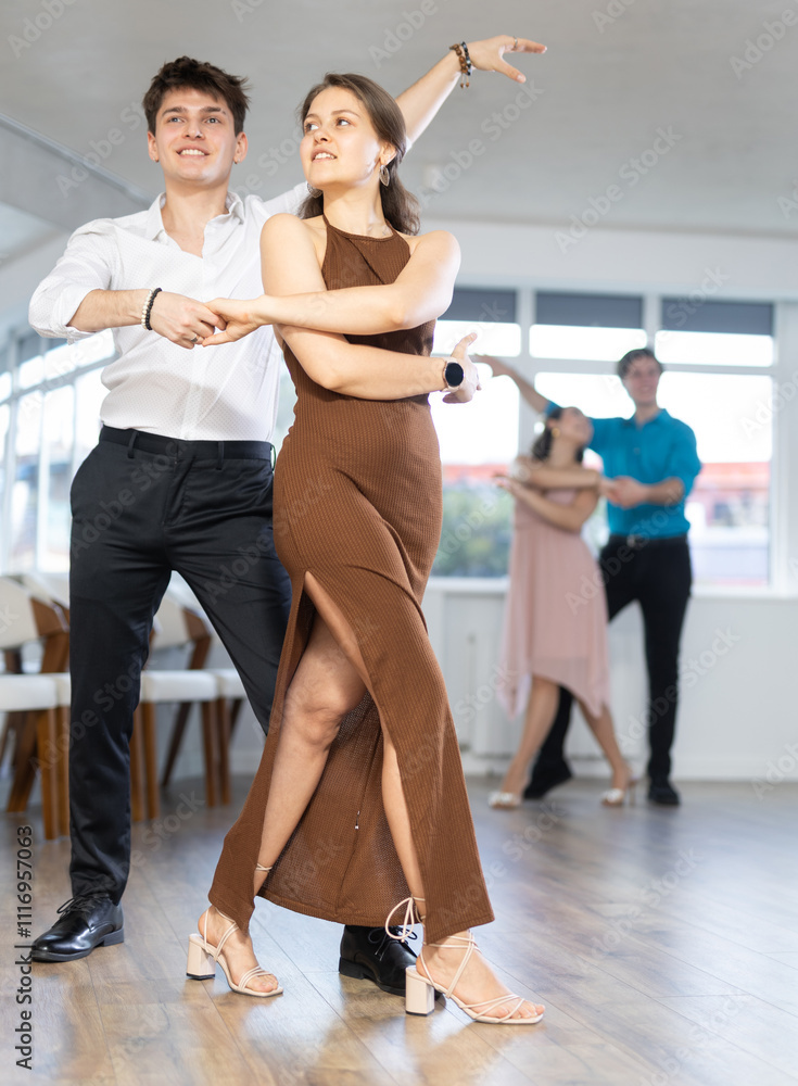 Young woman and young man rehearsing social couples ballroom dancing in studio Young woman and young man rehearsing social couples ballroom dancing in studio