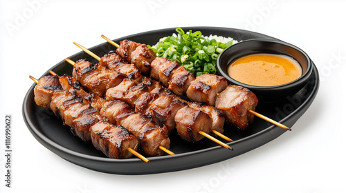 A plate of meat skewers with a dipping sauce