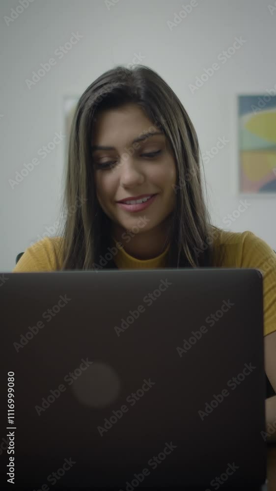 Dolly in of confident and cheerful caucasian brunette woman typing on a laptop, Young female professional writing an important email from her home in a modern living room. Remote working. Dolly in of confident and cheerful caucasian brunette woman typing on a laptop, Young female professional writing an important email from her home in a modern living room. Remote working.
