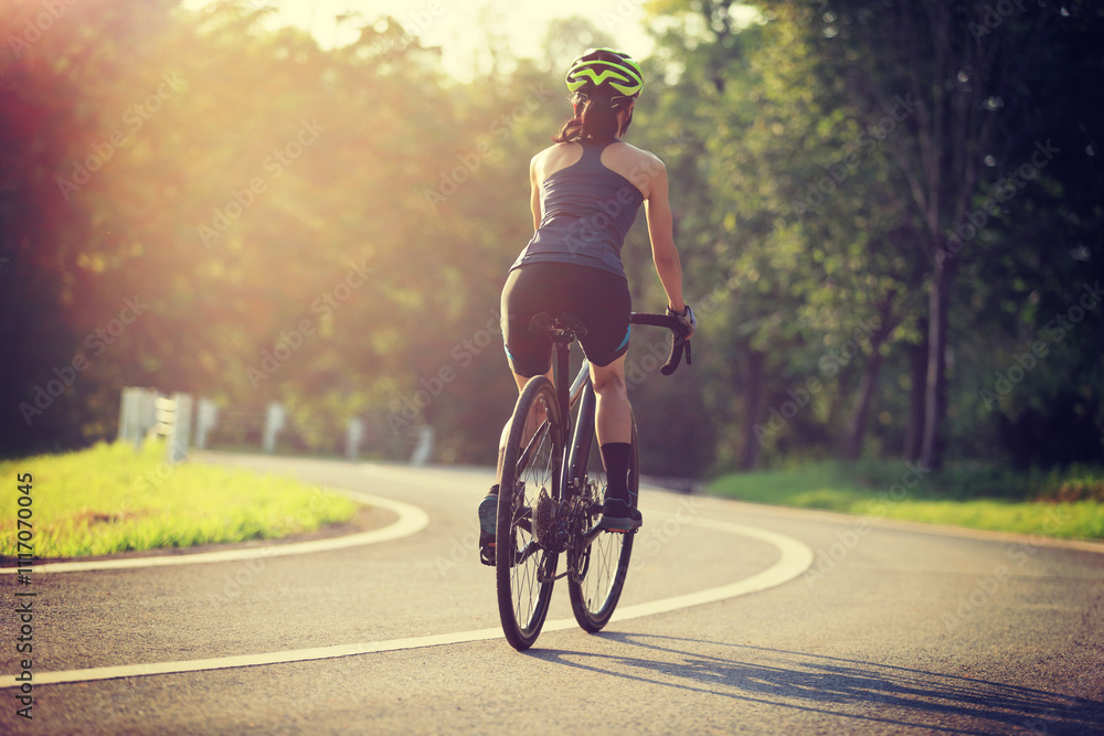 Obraz premium Woman cyclist riding bike in summer park