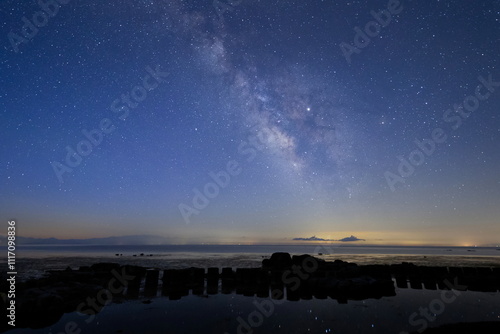 Obraz na płótnie 夜明けの能登半島の海辺に光る星あかりと天の川 w salonie