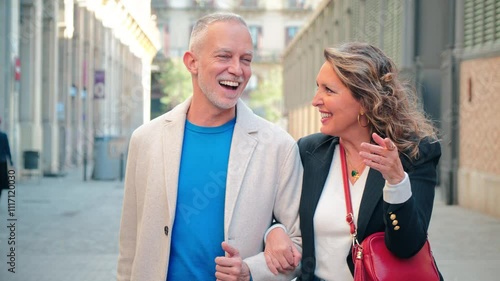 A Engaged, Mature Couple Stroll Hand in Hand Through the Lively, Charming City Streets, Pointing Out Sights and Conversing with Genuine Affection, Enthusiasm. Mid Adult People Sightseeing Outside