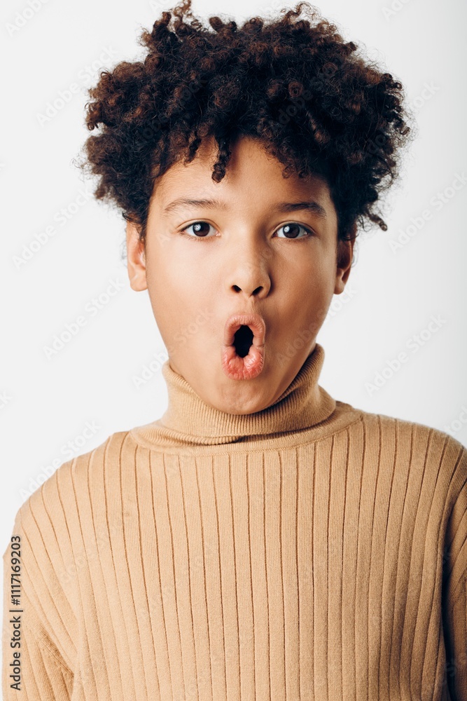 Excited young african american boy expressing joy and amazement with wide open mouth against a clean white background Excited young african american boy expressing joy and amazement with wide open mouth against a clean white background