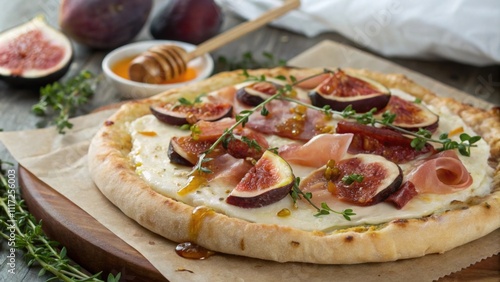 A rusticstyle pizza displays a handtossed crust that sports a rough artisanal texture. The surface is adorned with slices of ripe figs prosciutto and a generous amount of melted photo