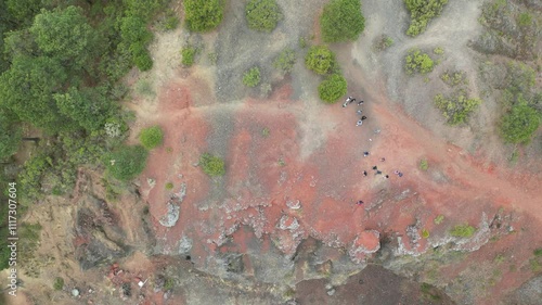 Red and brown rocky area with trees in the background
