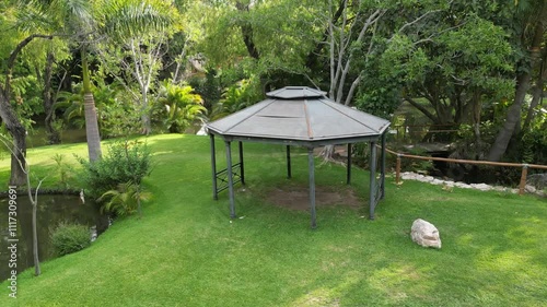 Small gazebo sits in a lush green field