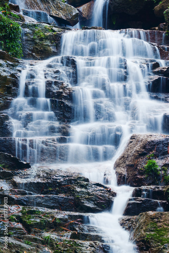 Waterfall cascading over rocky terrain in tropical forest at Vietnam