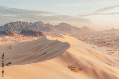 Serene desert landscape with rolling sand dunes and distant mountains under a soft sky. photo