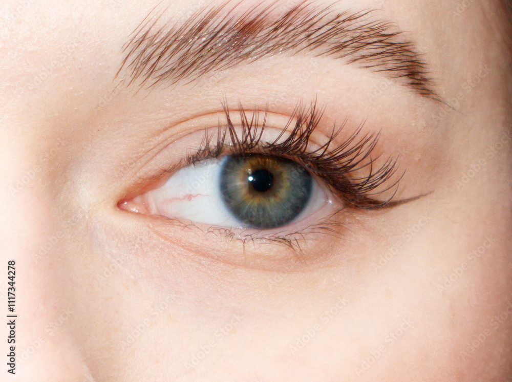 Obraz premium A woman's eye is open and has a greenish-blue hue